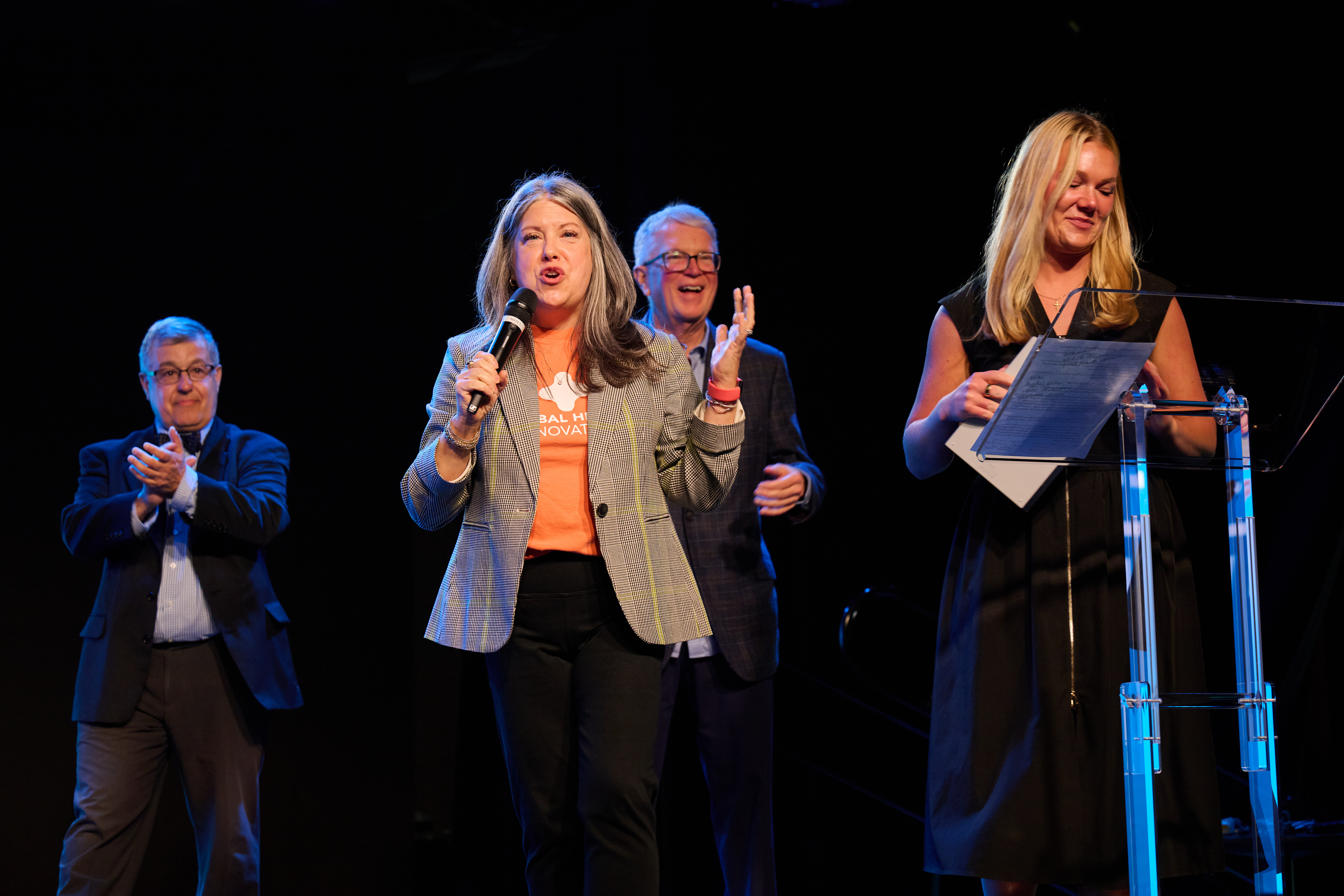 Award and presentation ceremony with people on stage with microphones during recognition ceremony at Global Health Innovators Summit